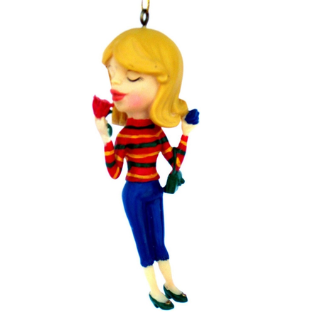 ornament of a blonde girl wearing a red striped shirt, holding a red rose up to her nose.