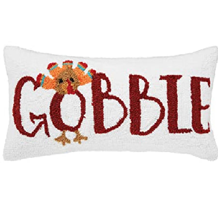 rectangle white pillow with rust color word gobble with the O looking like a turkey.