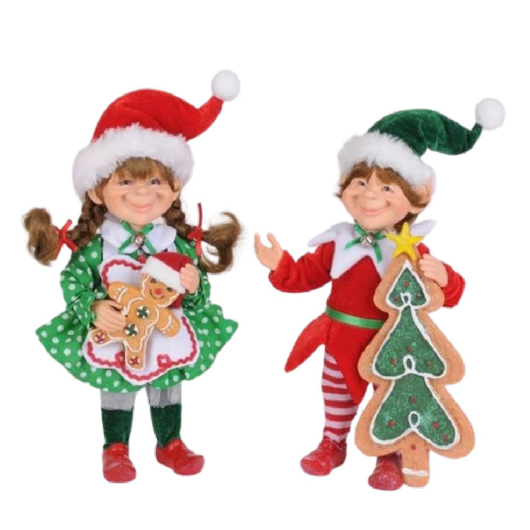 set of 2 little elf figurines, the girl is wearing a green polka dot dress, and both of them are holding gingerbread cookies.