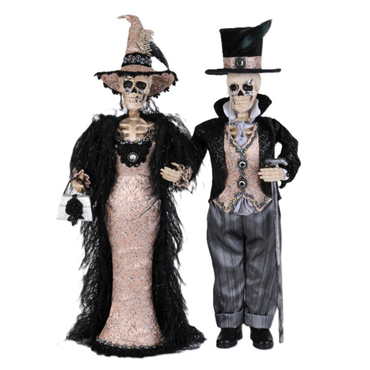 Karen Didion Harry and Lucy skeleton pair in elaborate Halloween outfits with brocade, feather trim, jeweled accessories, and top hats