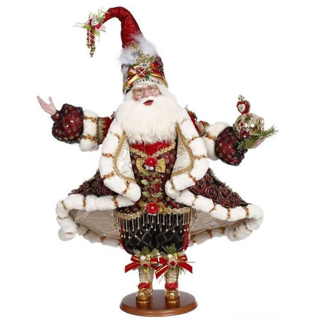  santa in beaded and fur trimmed coat, entire outfit adorned with ribbons, and holding a heart ornament.