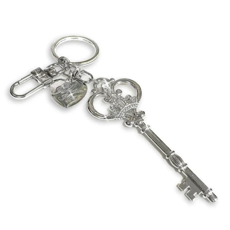 Silver key-shaped purse charm keychain with high-gloss finish clipped to a bag accessory, 3.75 inch Jacqueline Kent design