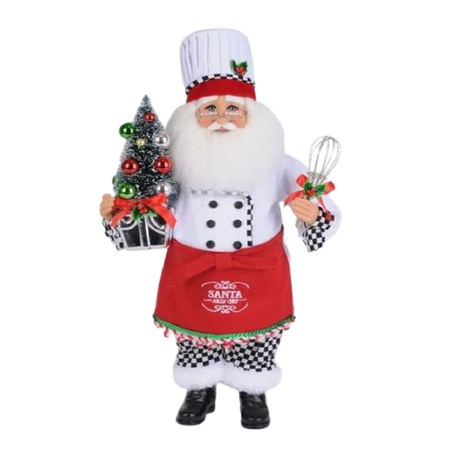Santa figurine dressed in a chef's coat and hat, red apron and holding a whisk.