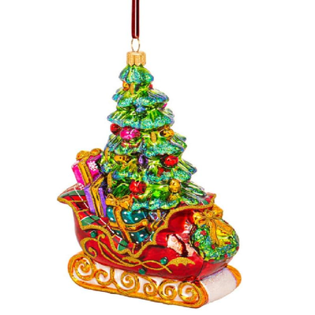 A Christmas ornament shaped like a decorated Christmas tree in a red sleigh carrying gifts, with a red hanging ribbon at the top, shown on a plain white background.