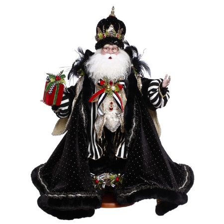 Decorative figure of Santa in a black robe with festive decorations on a white background