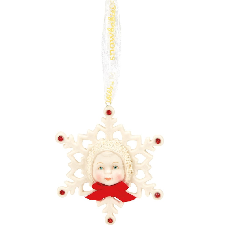 Decorative snowflake ornament with a face and red bow on a white background