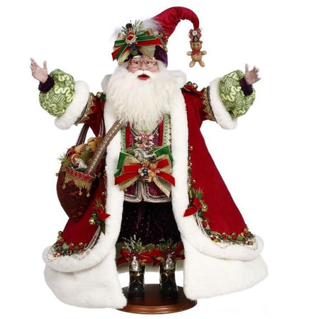 Santa dressed in long red coat with white fur trim, with a satchel full of gifts, his hat has a teddy bear on it.