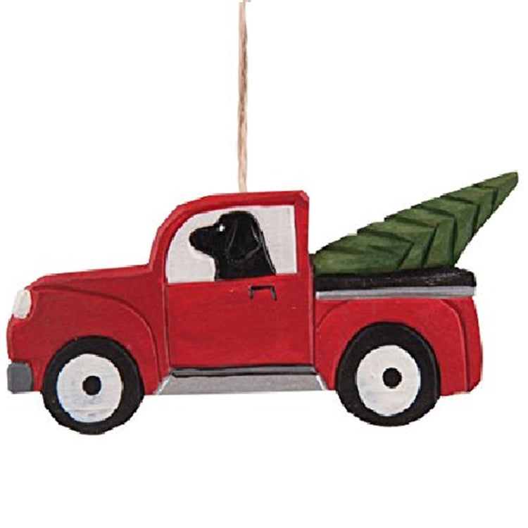 red pickup truck with a black lab dog in the drivers seat. Cut tree in the bed of the pickup.