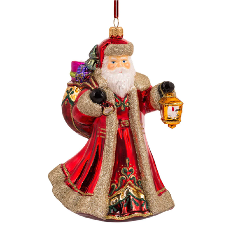 Blown glass ornament of Santa in long red coat and hat, holding lantern.
