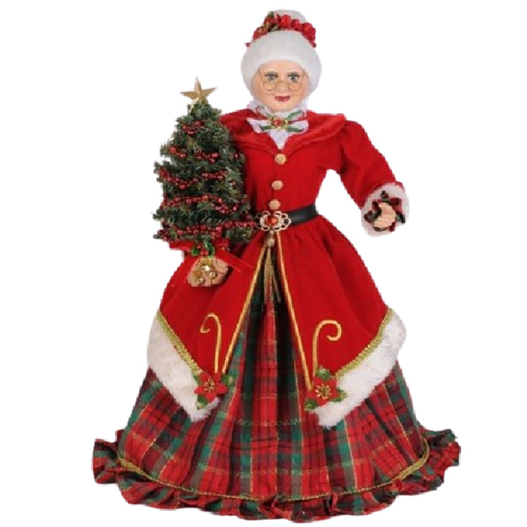 Figurine of Mrs. Claus standing. White hair in a bun with red head band. Red plaid dress with red jacket trimmed in white faux fur.  She carries a chistmas tree.