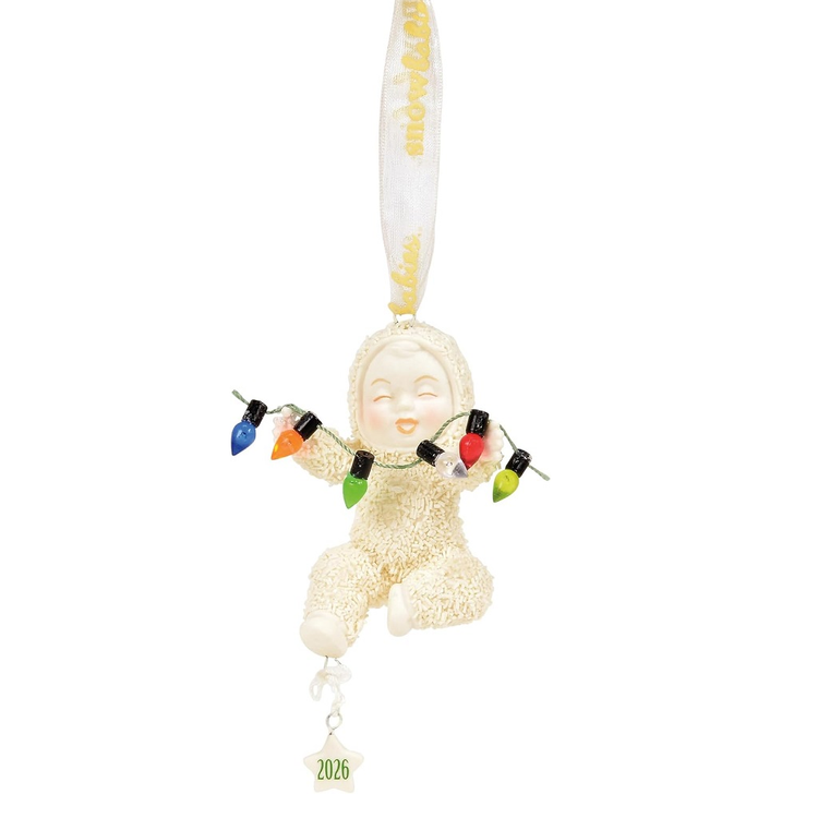 Snowbaby ornament holding a string of faux christmas lights, there's also a star charm with the year 2026.