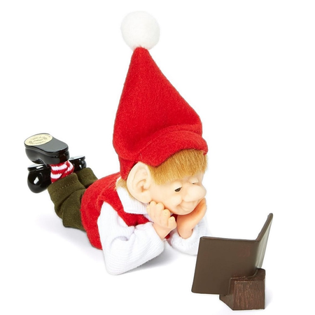 linus is a hand carved resin and fabric elf figurine, shaped to look like hes laying on his tummy and reading a book.