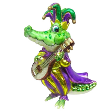 ornament shaped like a gator standing up playing a banjo. Wears  traditional Mardi Gras outfit in green, gold and purples with a jester hat.