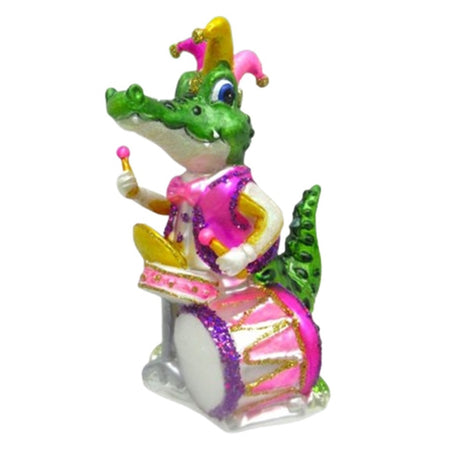 ornamet designed as a gator playing a drum set with 2 drums and cymbols. Gator is green with jester ht and pink vest. Drum set in pink with purple accents
