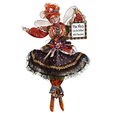 Fairy figure dressed in orange with a black skirt and holding a sign that says This witch can be bribed with chocolate.