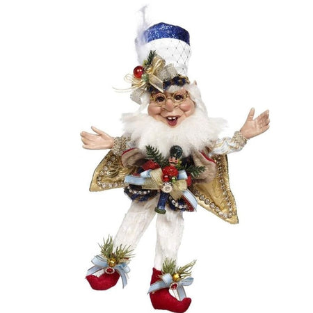 Elf figure with white pants, red booties, white tall hat with blue top, gold cape and red vest with a nutcracker tied on with a bow.