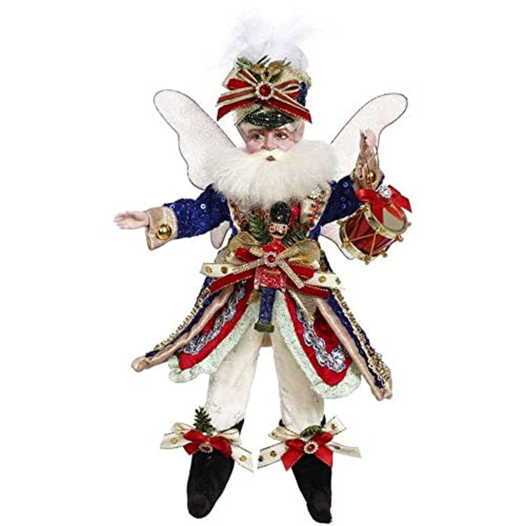 Fairy figurine wiht wings.  He wears white pants, black booties and blue and red jacket with a nutcracker on a jacket bow