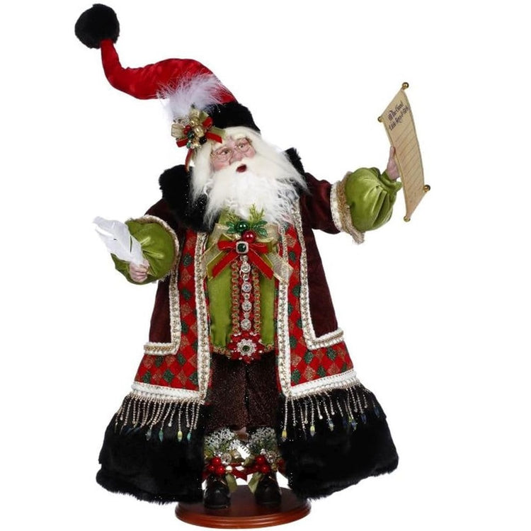 Standing Santa figure holding a list in one hand and a feathered pen in the other. Full coat and pointy hat. Red and black velvet type material with embellishments.