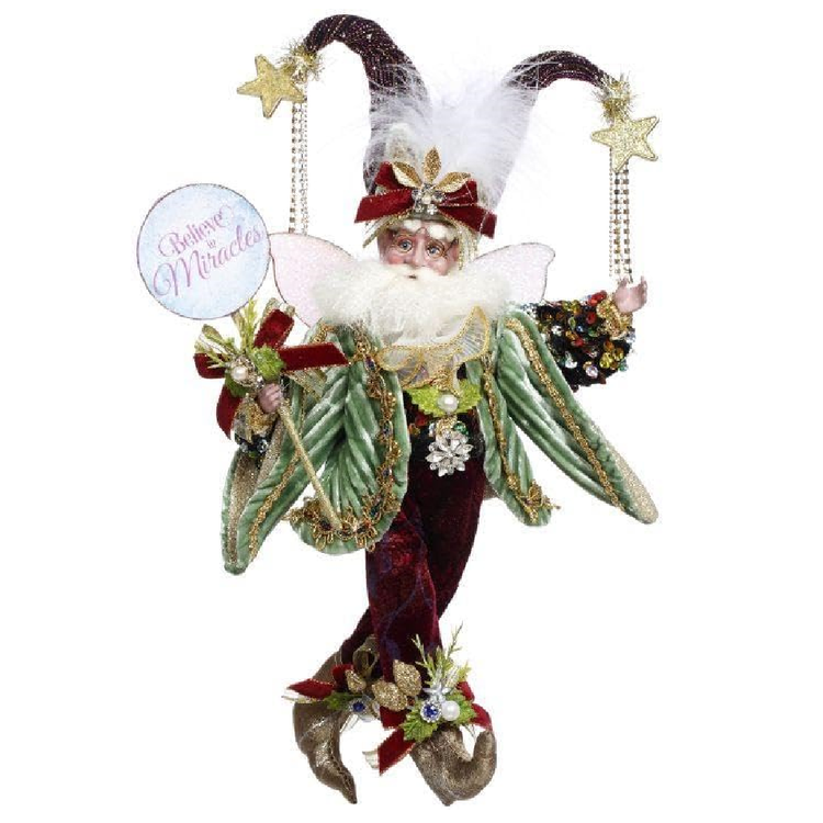 Decorative fairy figure with festive attire and 'Believe in Miracles' sign on a white background