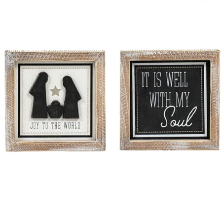 photo shows both sides of the sign. one side shows a nativity with text: Joy to the world. The other size is black with white writing: It is Well with My Soul