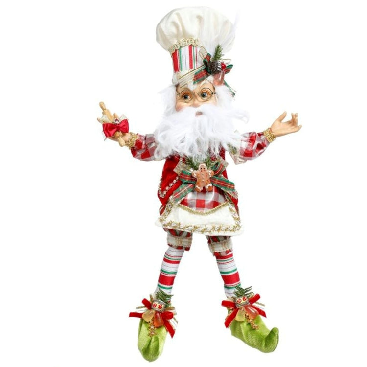 standing elf with white chef hat and green booties. Red and white stripe on hat base and socks. Gingerbread man on vest