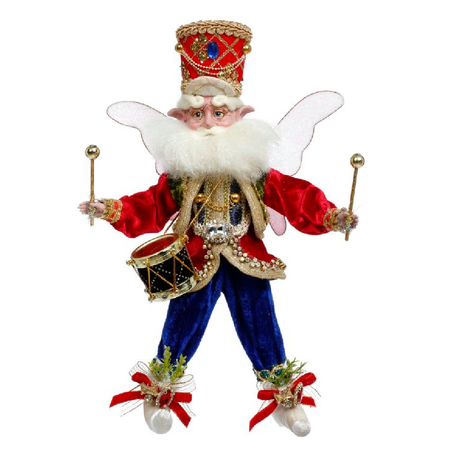 Bearded fairy in blue pants, red coat and red soldiers hat. wearing a snare drum and holding drum sticks.