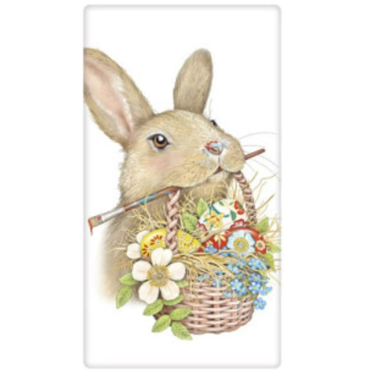 white flour sack towel with tan bunny holding an easter basket and paintbrush in its mouth.