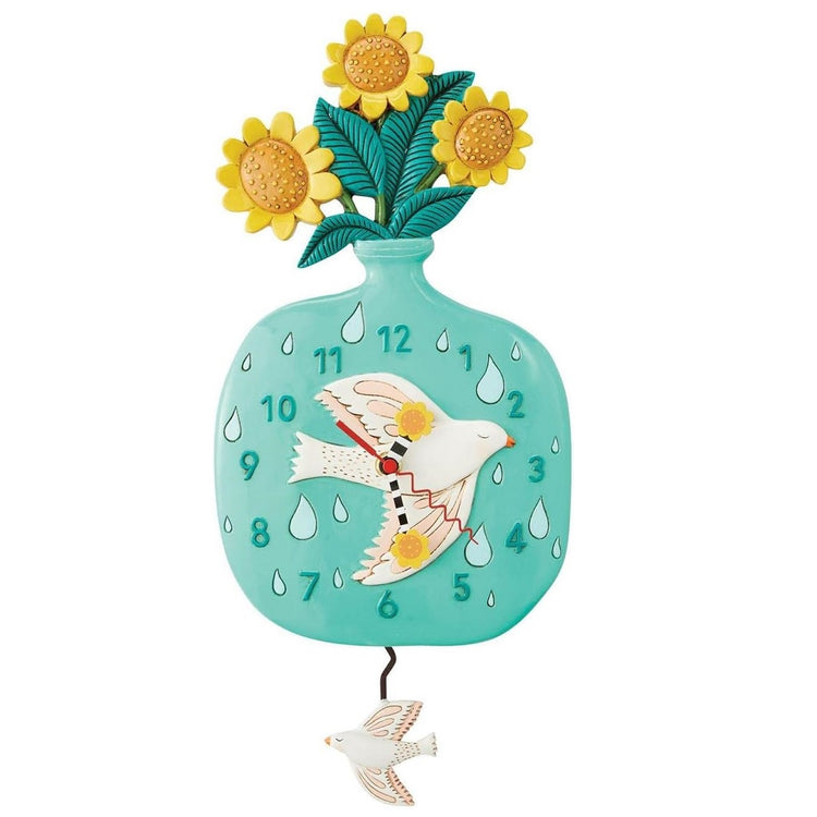 clock shaped like a vase with sunflowers, a bird pattern is on the vase as well as a bird shaped pendulum.