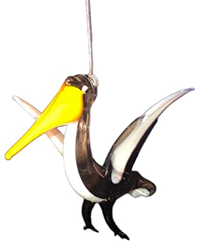 Glass ornament shaped like a Pelican with a yellow beak, white body with shades of black.