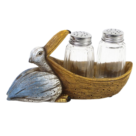 Resin pelican figurine with glass salt and pepper shakers in its mouth.