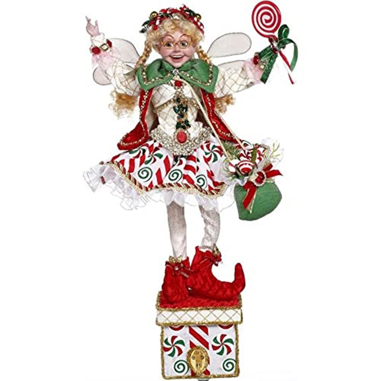 fairy on a box with a hook to hold stockings.  The fairy is a girl with golden blonde braids and round glasses.  She waears red booties, white skirt decorated with peppermint sticks and she carris a round peppermint lolipop