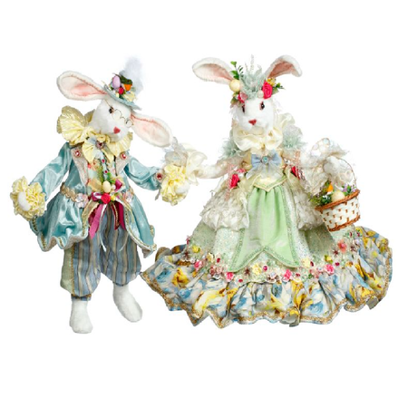 two white rabbits, one in blue and yellow suit, one in light green and yellow gown with flowers.