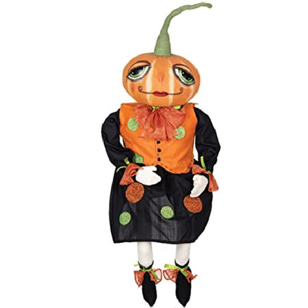 girl figure with a pumpkin for a head. The pumpkin has a tall green stem and a painted face. She wears a black dress with orange vest, both have orange and treen polka dots.