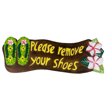 Brown wood sign with green flip flops & pink & white hibiscus. Saying 'please remove your shoes'.