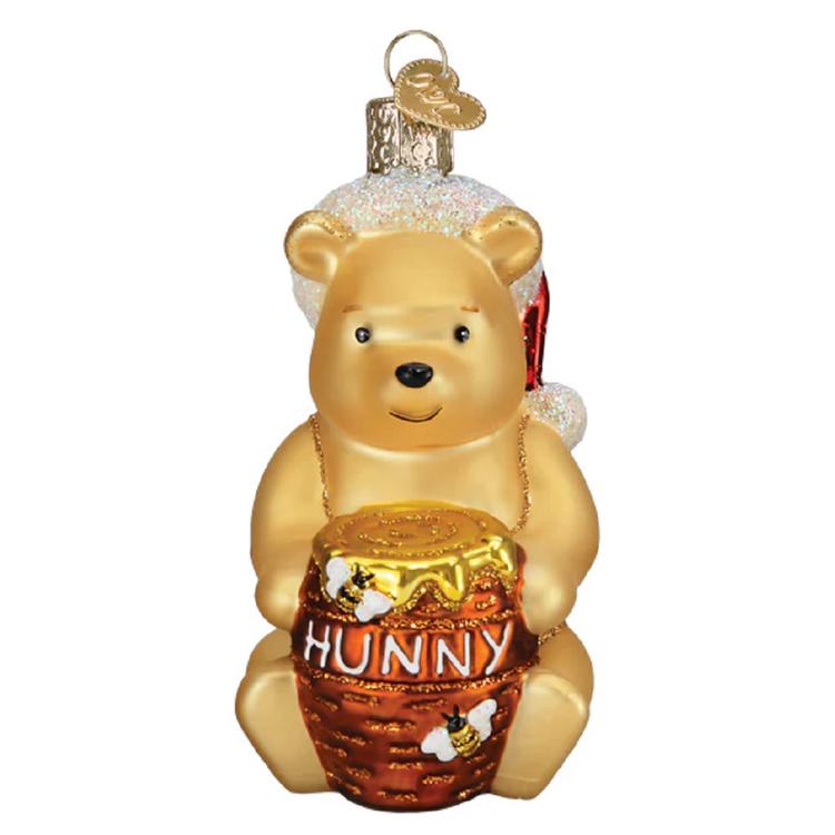 blown glass winnie the pooh ornament, he's wearing a santa hat and holding a jar of hunny