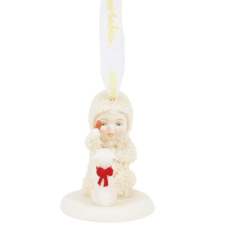 snowbaby ornament feeding a treat to a puppy wearing a red ribbon.