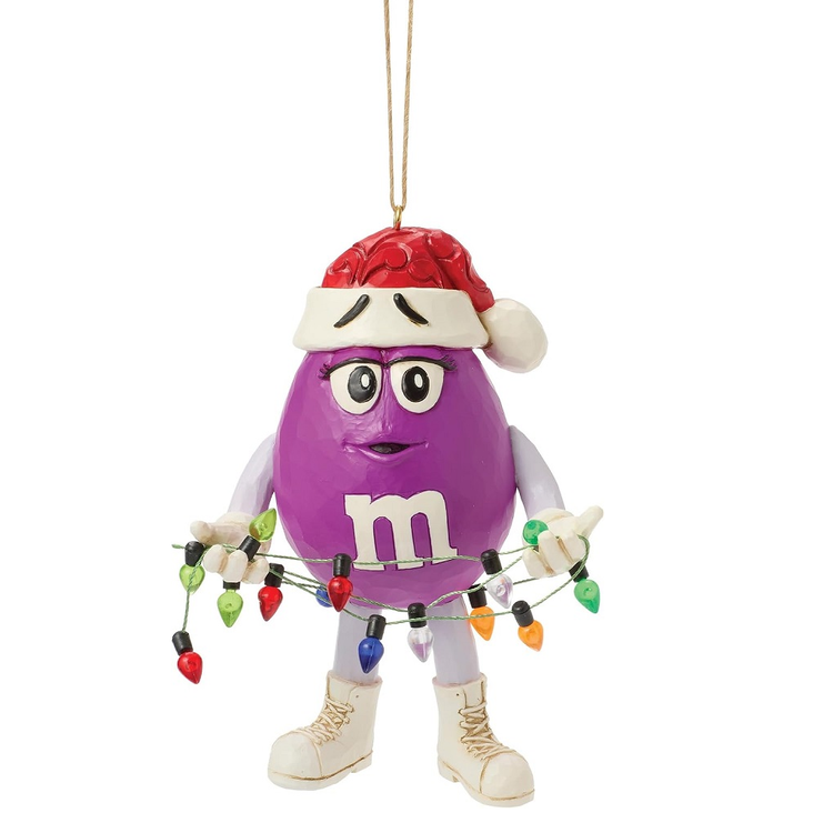 Purple M&M wearing a Santa hat and a string of faux Christmas lights.