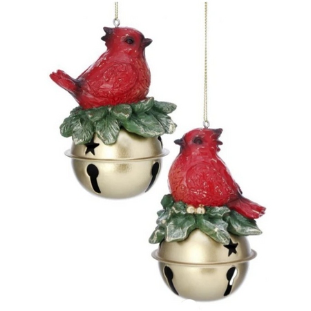 2 hanging ornaments with  a red cardinal sitting on top of a jingle bell with greenery accent under the cardinal