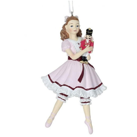 clara ballerina holding a nutcracker. She wears a pink dress with twhite ruffles and a bow in her hair