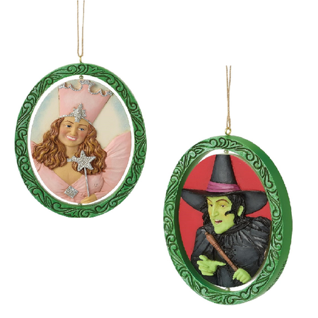 Green oval shaped ornament, center part rotates, one side showing Glinda the Good Witch, the other side showing The Wicked Witch of the West.