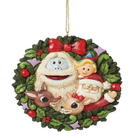 Decorative Christmas ornament with elf, reindeer, and Santa figure on a green wreath.