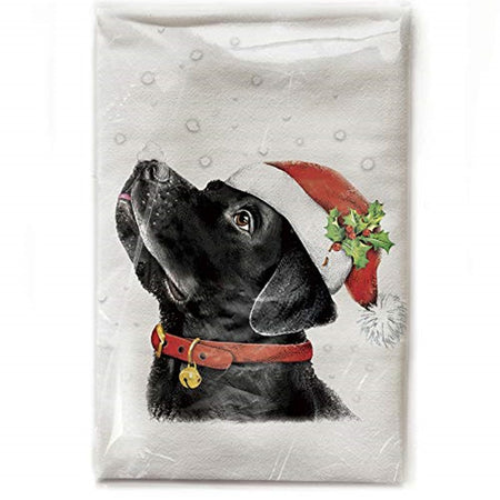 White kitchen towel with a black lab dog wearing a santa hat in the snow.