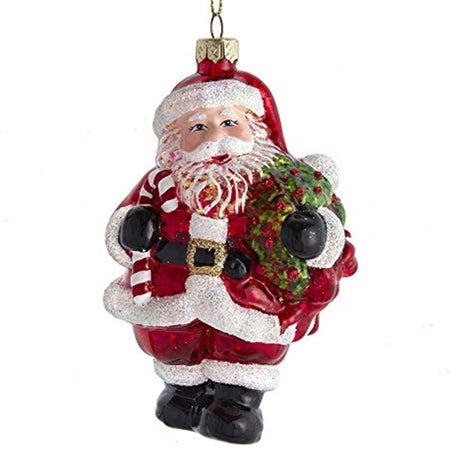Santa shaped ornament wearing the traditional red with white trim carrying a candy cane and a wreath
