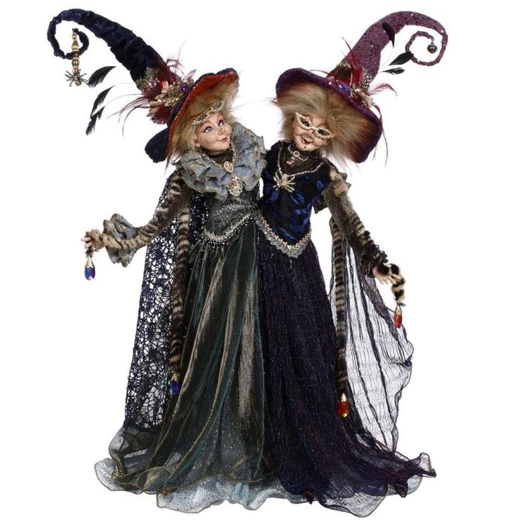 Siamese twin witches figurine, One in a dark blue dress and one in dark grey, both with elegant hats.