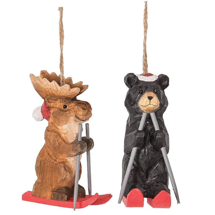 two wood carved ornaments, one is a moose, one a black bear, both are skiing.