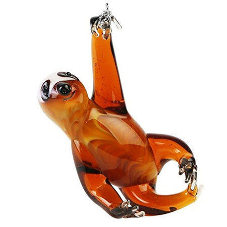 Hanging ornament shaped like a sloth hanging from a tree. Brown glass with clear paws and brown eyes, nose and mouth.