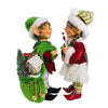 side view of 2 standing elf figures, 1 boy and one girl. The girl holds a peppermint lollipop the boy a bag of gifts 