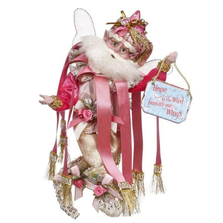 bearded fairy in pink outfit with long ribbons coming off collar. Holding a sign that says "hope is the wind beneath our wings"