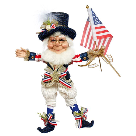 Bearded elf figurine dressed in red white and blue suit, blue top hat, and holding an American Flag.