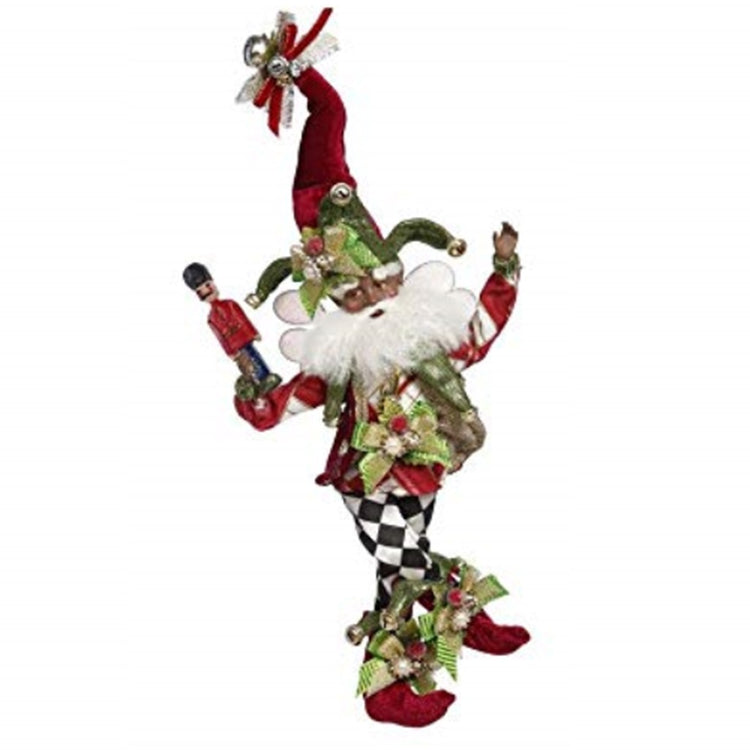 Fairy figure wearing harlequin pattern pants in traditional black and white, red  booties and jester type hat in red and green. Carries a nutcracker.